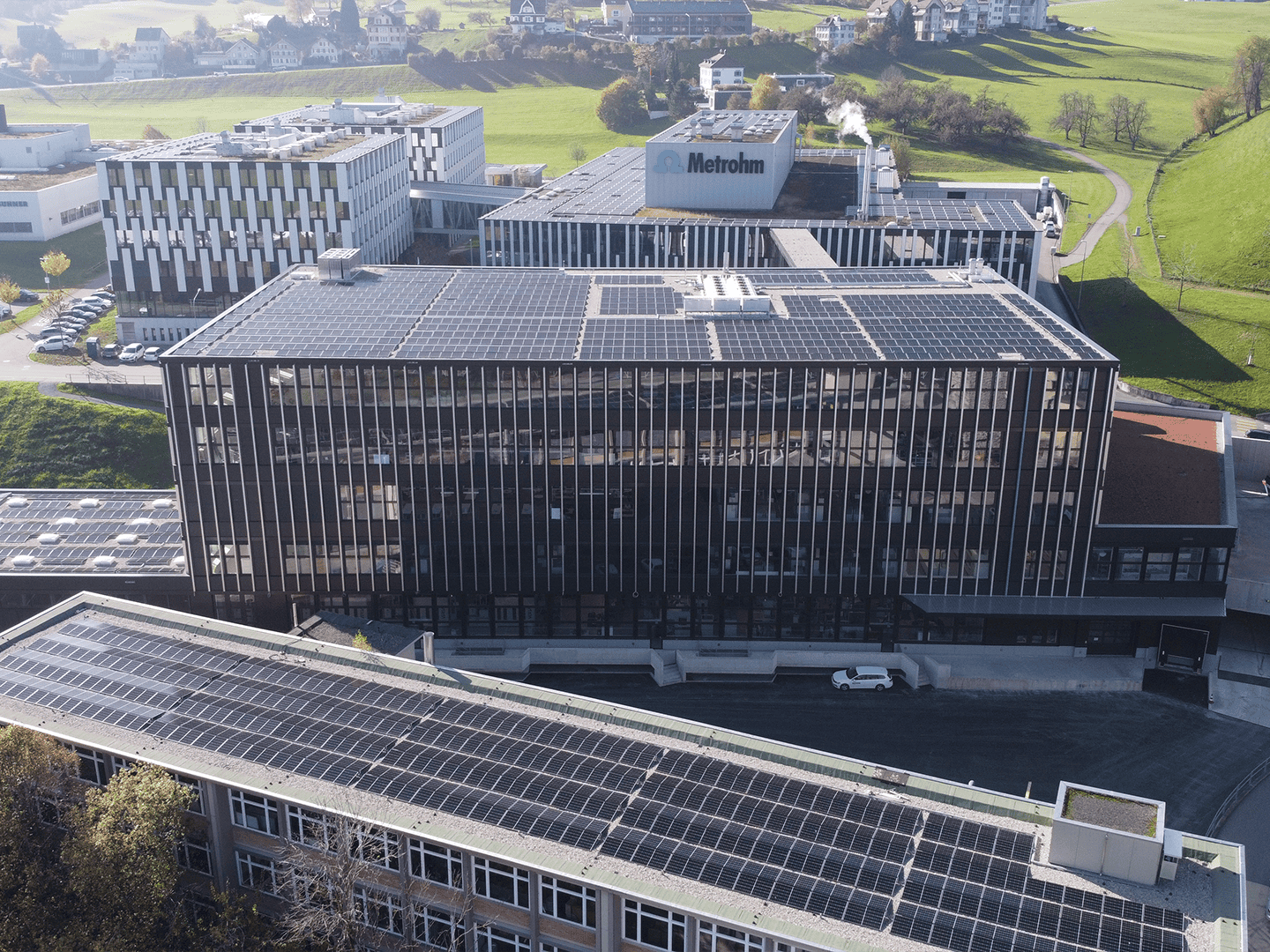 Solar panel installation on building rooftops in an office complex, emphasizing renewable energy for corporate sustainability efforts.